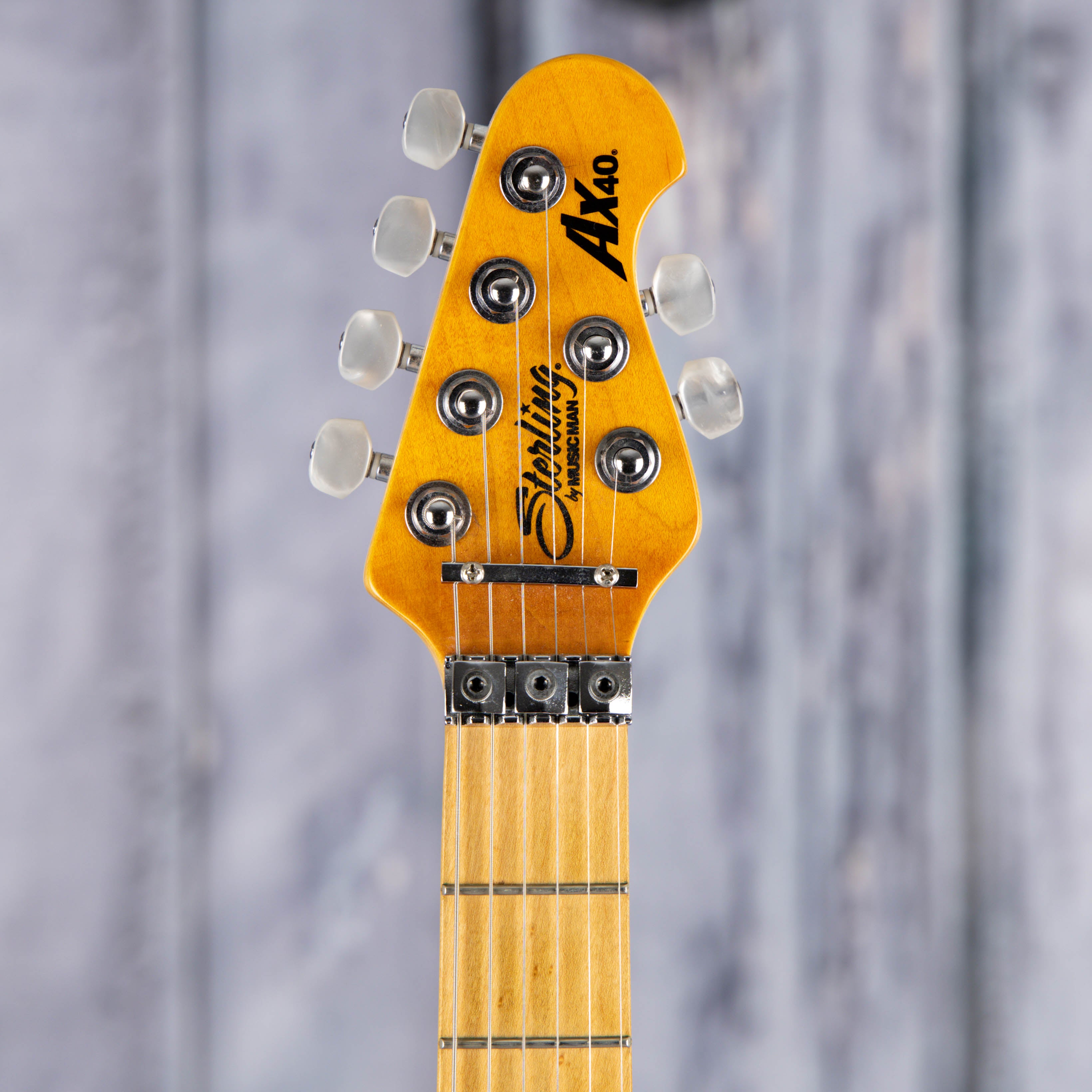 Used Sterling By Music Man AX40 Electric Guitar, 2015, Transparent Amber, front headstock